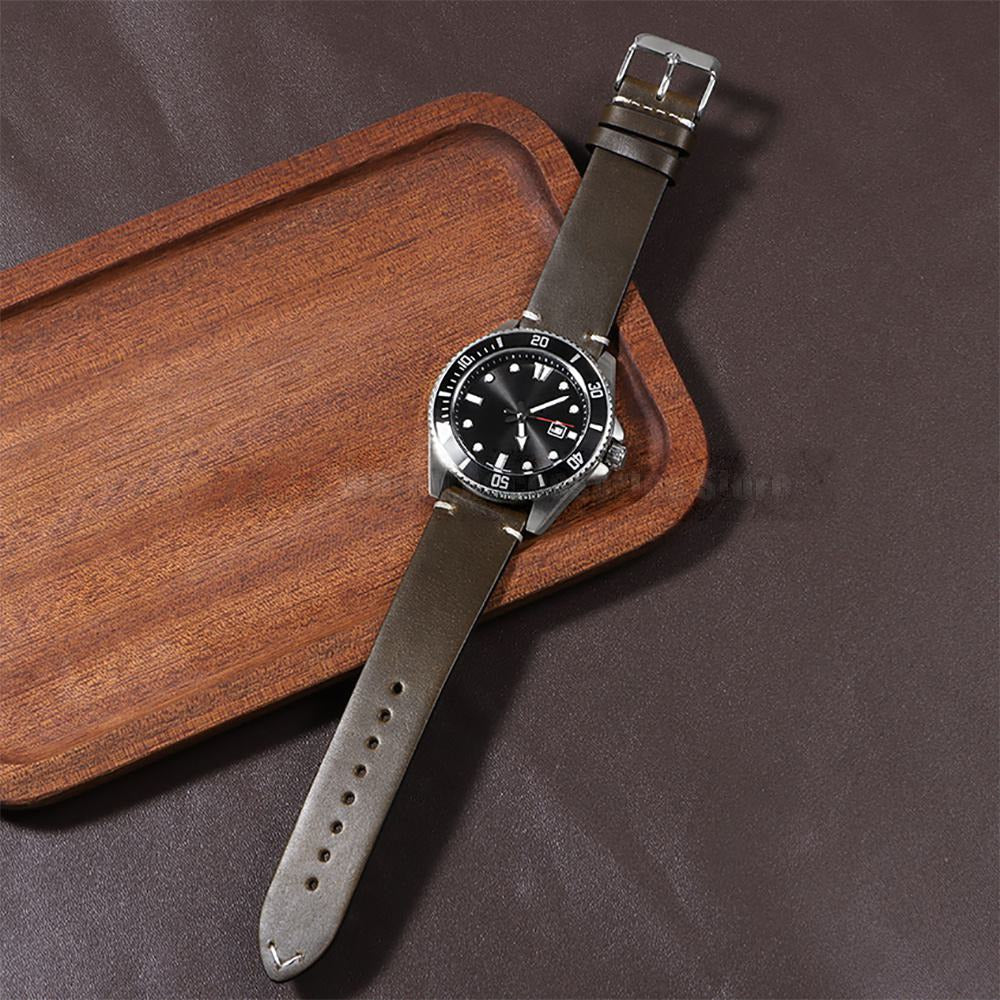 Vintage oil wax leather watch strap fitted to a dive watch on a wooden tray