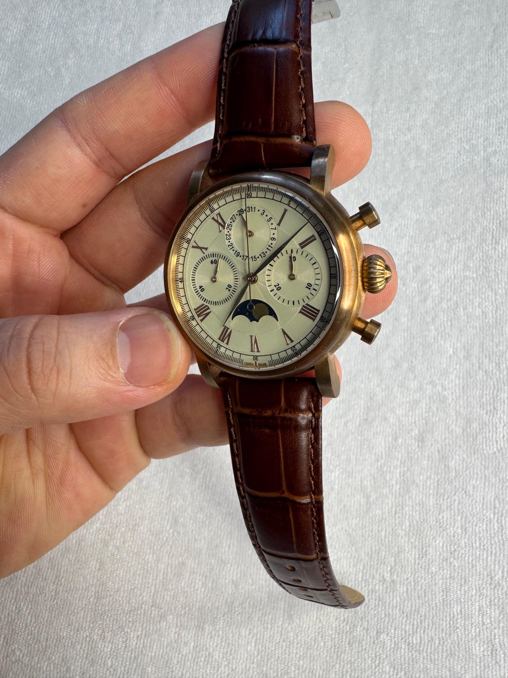 Sea-Gull ST19 moon phase chronograph in hand, bronze-tone case with cream guilloche dial and brown leather strap